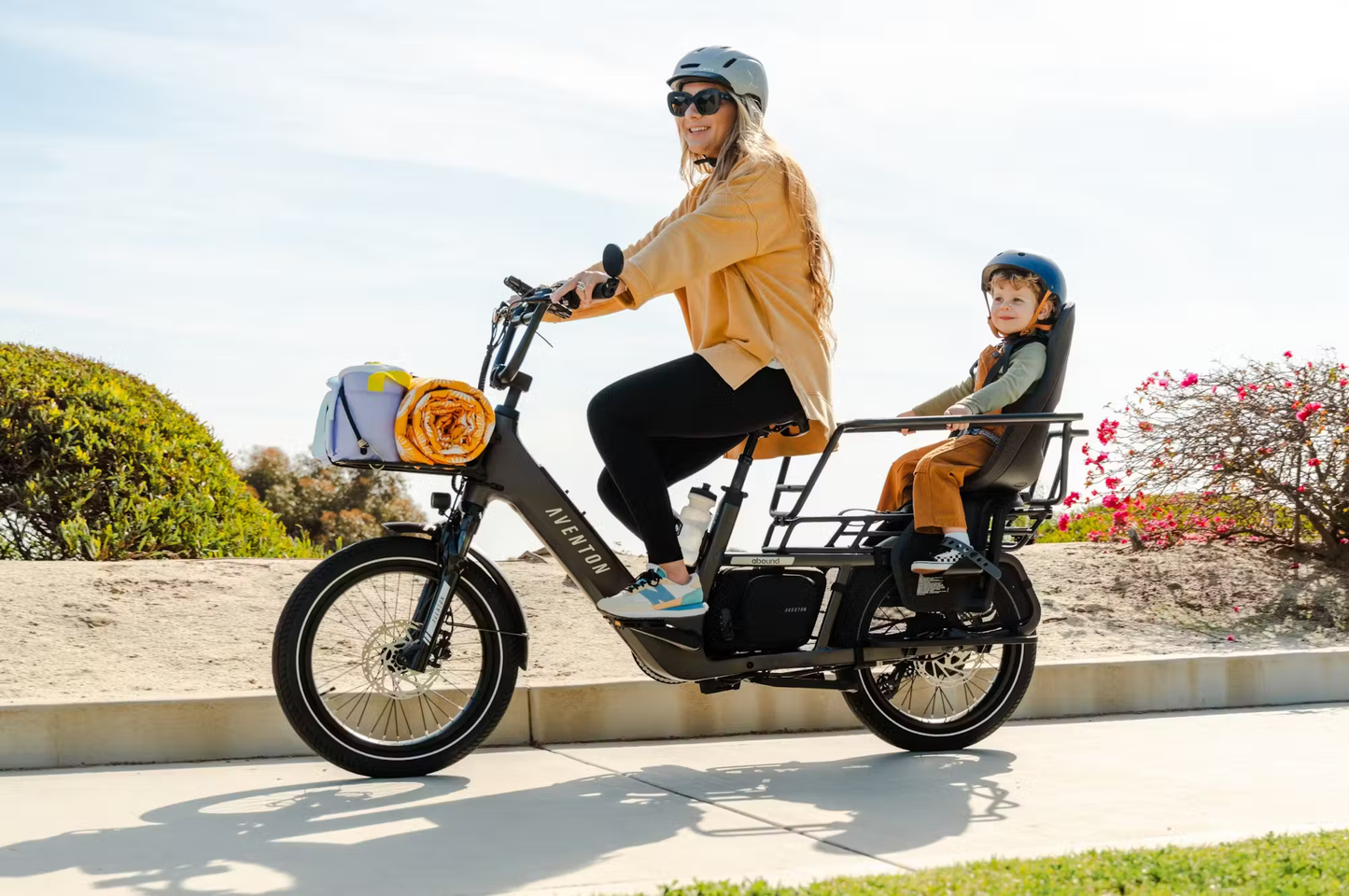 Rex E-Bikes Aventon Abound LR cargo e-bike carrying a woman and child with front and rear cargo