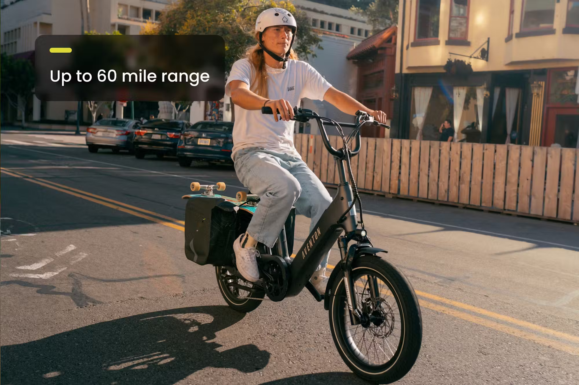 Rider on Rex E-Bikes Aventon Abound SR cargo e-bike with up to 60 mile range riding on city street