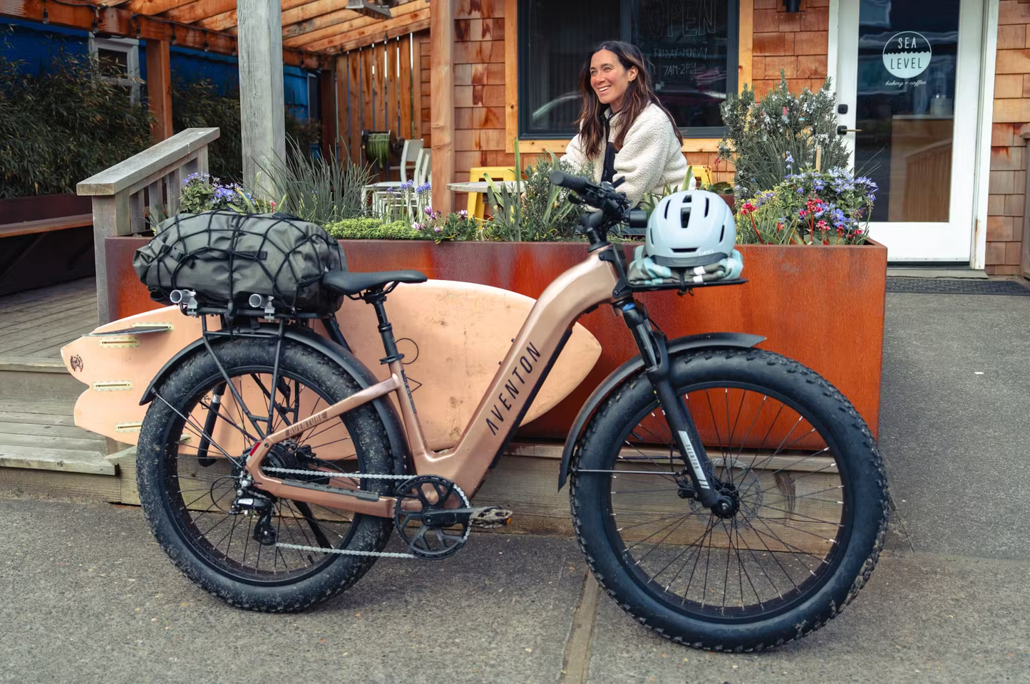 Rex E-Bikes Aventon Aventure.3 step-through e-bike in bronze with fat tires and a helmet attached