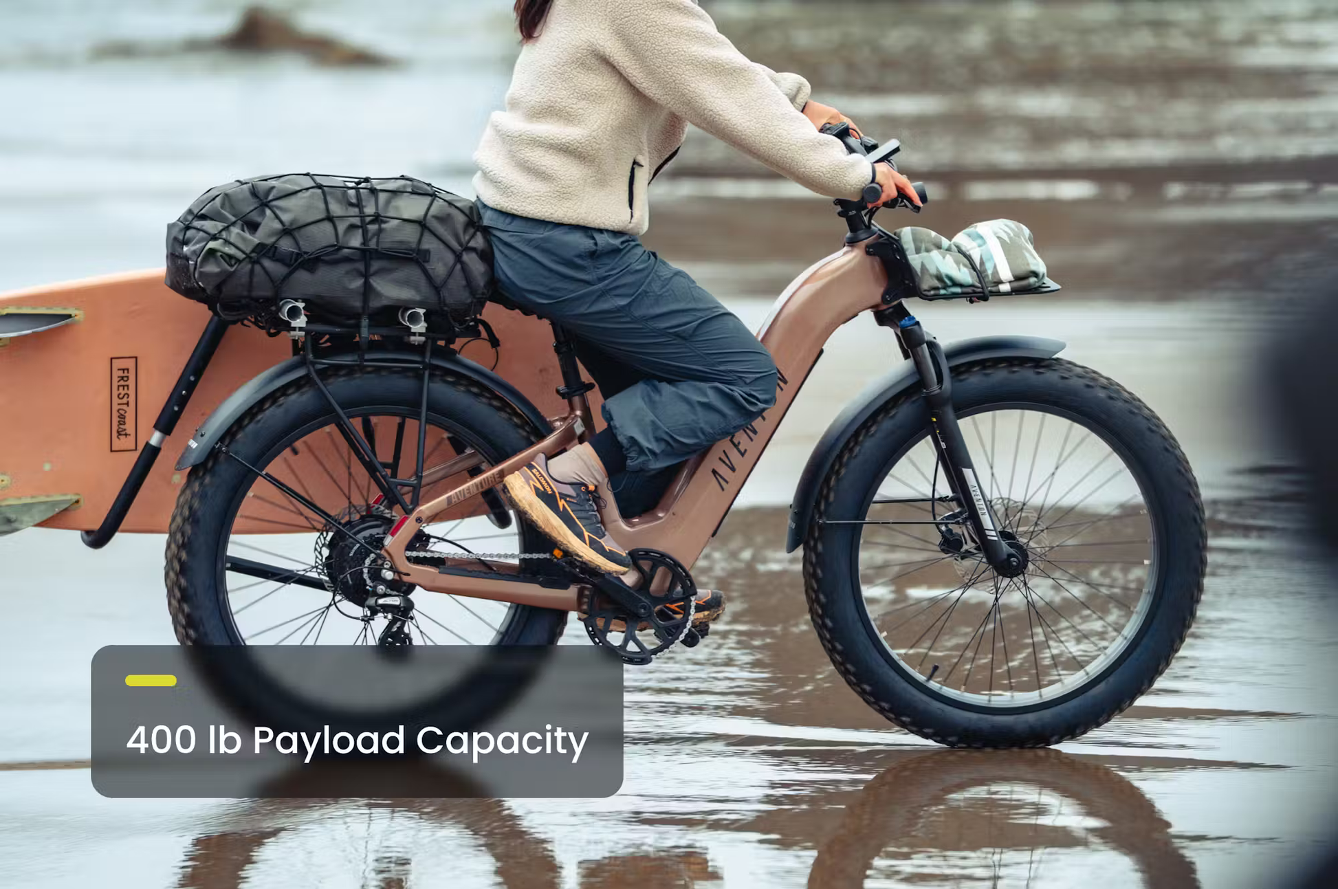 Rex E-Bikes Aventon Aventure.3 step-through e-bike with cargo rack and 400 lb payload capacity in a muddy outdoor setting