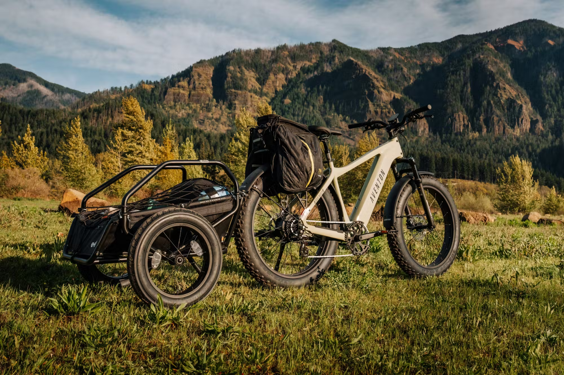 Rex E-Bikes Aventon Aventure.3 e-bike for sale in white with cargo trailer in a scenic mountain landscape