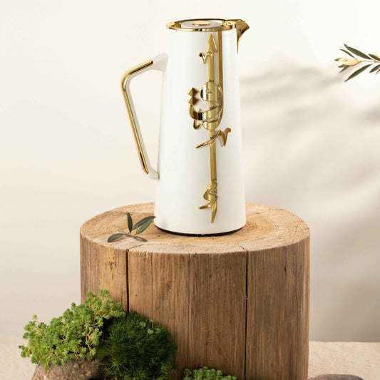Pearl white gold vacuum flask with elegant gold handle and decorative design on wooden stump
