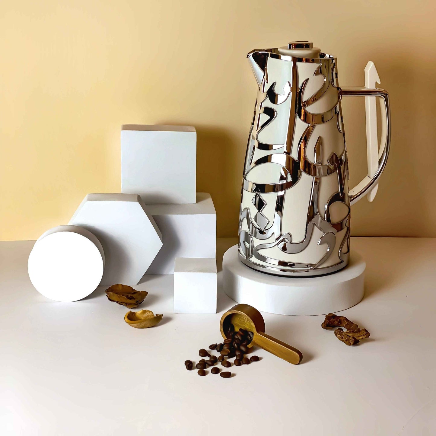 Otantik Home luxury vacuum flask with reflective silver design next to coffee beans and geometric white blocks