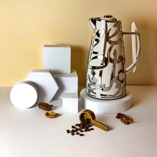 Otantik Home luxury vacuum flask with reflective silver design next to coffee beans and geometric white blocks