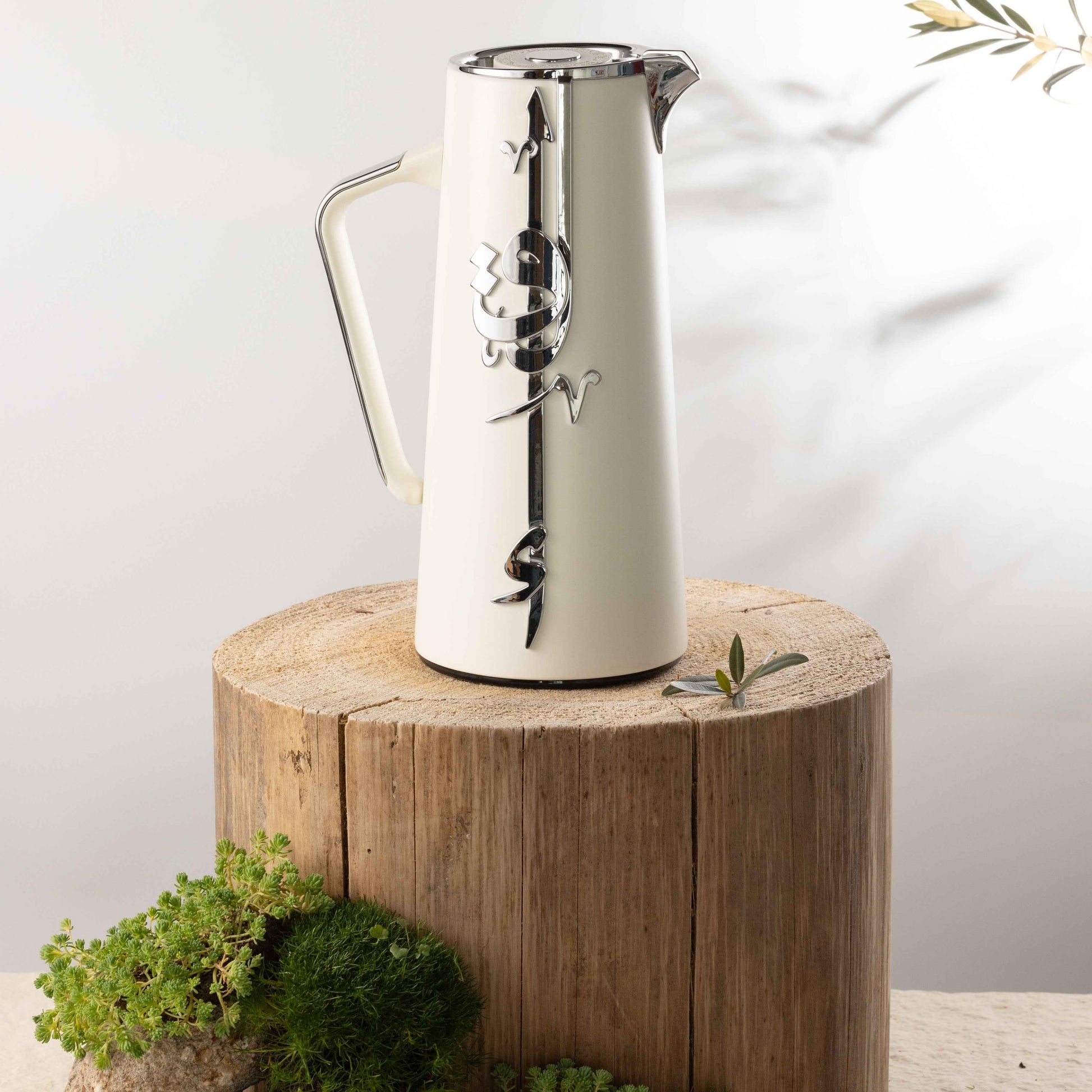 Otantik Home pearl white vacuum flask with silver decorative design on a wooden stump