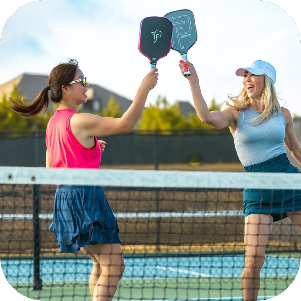 Two women playing pickleball outdoors using Titan Ignite 16S pickleball paddle by Titan Pickleball