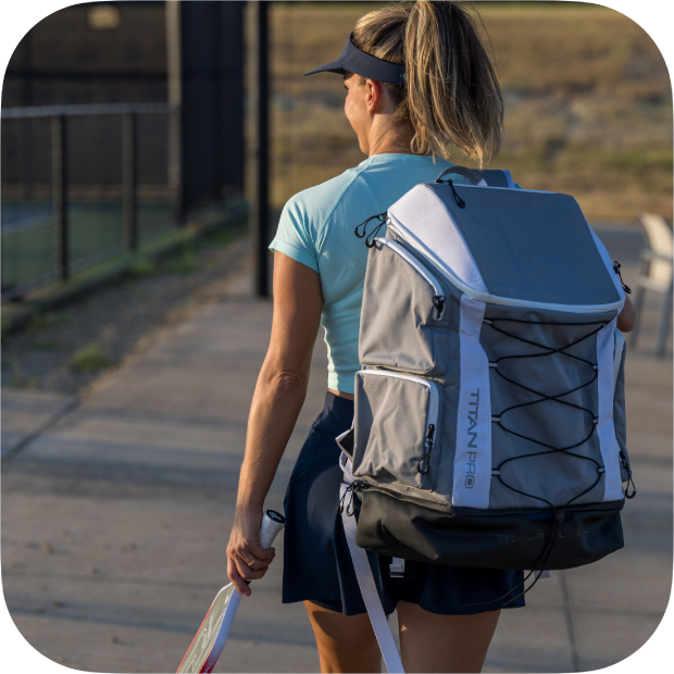 Woman carrying Titan Pickleball Backpack while holding a pickleball paddle outdoors